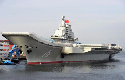4K Ultra HD PC desktop wallpaper showing Chinese aircraft carrier Liaoning — a gray warship docked with visible flight deck and bow, Chinese naval flag flying.