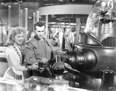 A scene from the classic film Forbidden Planet, featuring Robby the Robot interacting with two characters in a retro-futuristic setting, captured in a black-and-white HD desktop wallpaper.
