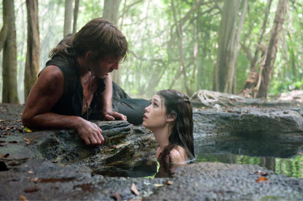 A scene from *Pirates of the Caribbean: On Stranger Tides* featuring Syrena (Astrid Bergès-Frisbey) and Philip (Sam Claflin) in a lush forest setting. 