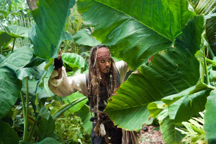 Jack Sparrow, portrayed by Johnny Depp in Pirates of the Caribbean: On Stranger Tides, navigates dense tropical foliage in this 4K Ultra HD movie wallpaper.