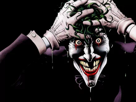 HD desktop wallpaper featuring the Joker from Batman: The Killing Joke comic, with a menacing grin and hands clutching his green hair against a black background.
