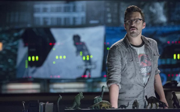 A scene from Jurassic World featuring a character analyzing miniature dinosaur figures in a high-tech control room, set against a backdrop of screens and digital displays.