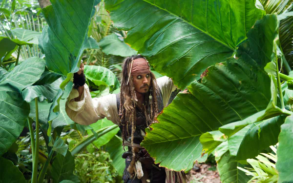 Jack Sparrow, portrayed by Johnny Depp in Pirates of the Caribbean: On Stranger Tides, navigates dense tropical foliage in this 4K Ultra HD movie wallpaper.