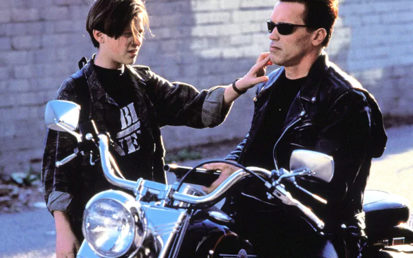 A scene from *Terminator 2: Judgment Day* featuring Arnold Schwarzenegger as the Terminator and Edward Furlong as John Connor, showcasing their bond on a motorcycle.