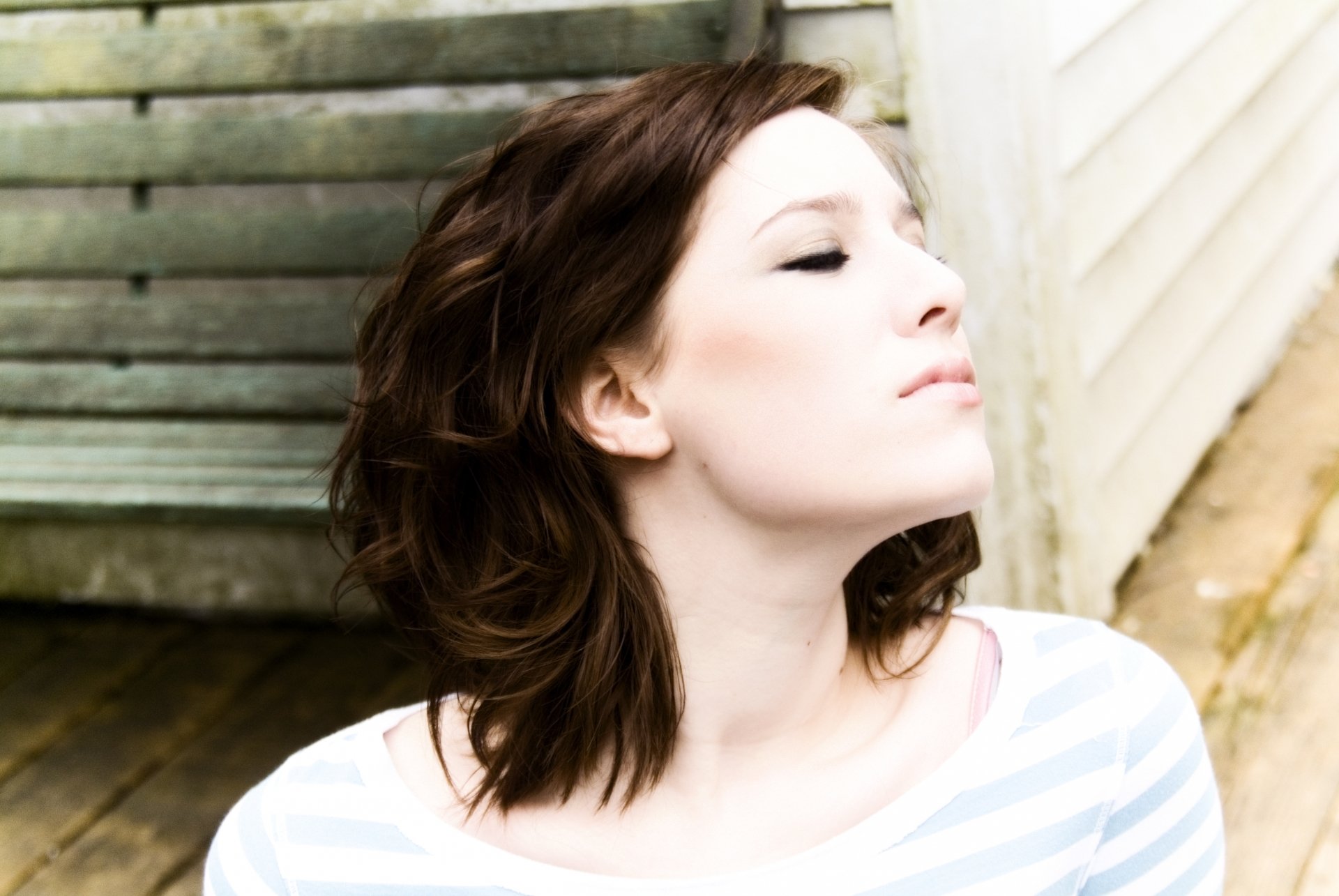 Profile of a woman with short brown hair against a wooden and light-colored background, rendered in 4K Ultra HD for PC desktop wallpaper and background.