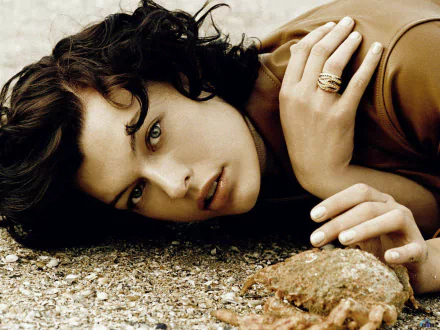 HD PC desktop wallpaper featuring a close-up portrait of celebrity Milla Jovovich lying on a textured surface, showcasing her intense gaze and natural beauty.