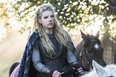 Lagertha, portrayed by Katheryn Winnick in the TV show Vikings (2013), stands confidently beside her horse in this striking 4K Ultra HD desktop wallpaper.