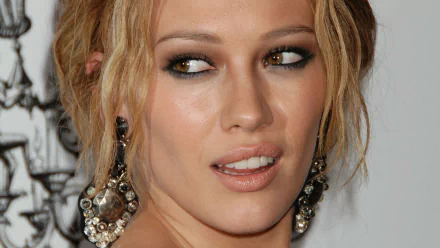 4K Ultra HD desktop wallpaper: close-up of a blonde celebrity woman with smoky eye makeup and large jeweled earrings, glancing to the side.