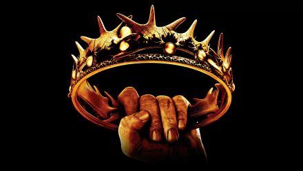 A dramatic image of a hand gripping a spiked crown against a dark background, inspired by the iconic themes of the TV show Game of Thrones, serves as an HD wallpaper for desktops.