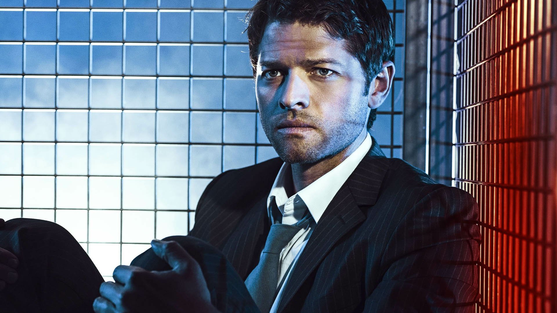 The image features a character from the TV show Supernatural, portrayed in a dramatic pose against a backdrop of colored lighting, creating a captivating HD desktop wallpaper.