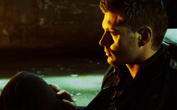 A dramatic HD wallpaper featuring a character from the TV show Supernatural, showcasing a contemplative moment with moody lighting and a focus on expression.