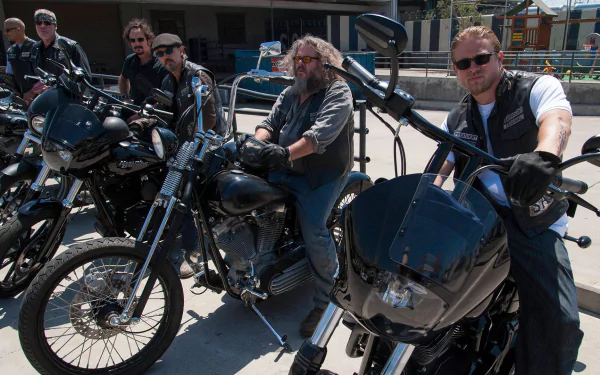 A scene from the TV show Sons of Anarchy, featuring a group of rough-looking bikers on black motorcycles, showcasing the show's intense atmosphere and camaraderie. High-definition wallpaper.