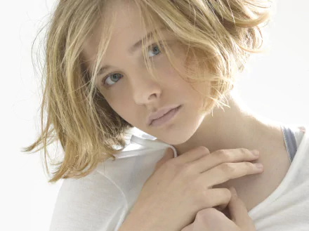 A close-up of Chloë Grace Moretz, showcasing her soft features and tousled hair against a light background. This HD image serves as a stylish desktop wallpaper.