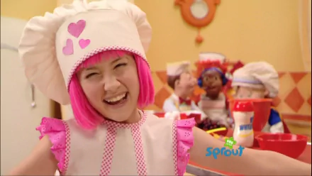 HD desktop wallpaper from the TV show LazyTown featuring Stephanie in a pink and white chef outfit smiling brightly in a kitchen setting.