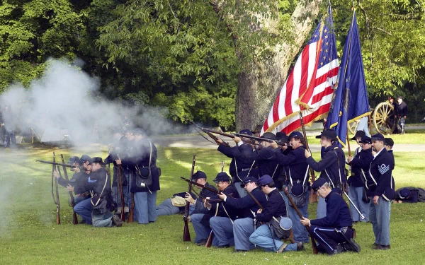 A captivating HD wallpaper depicting United States Army soldiers in Civil War attire, firing their weapons amidst smoke, with American and state flags prominently displayed.