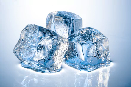 Close-up photography of three glistening ice cubes, showcasing intricate textures and reflections, set against a softly lit background. This image serves as a striking HD desktop wallpaper.