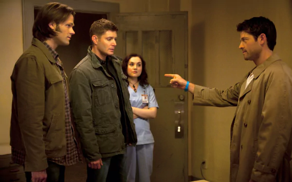 A scene from *Supernatural* featuring Sam Winchester (Jared Padalecki), Dean Winchester (Jensen Ackles), and Castiel (Misha Collins) with Meg Masters in a dramatic moment.