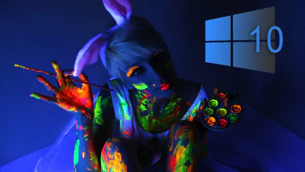 A vibrant HD desktop wallpaper featuring a person with colorful body paint and bunny ears, set against a dark background with the Windows 10 logo.