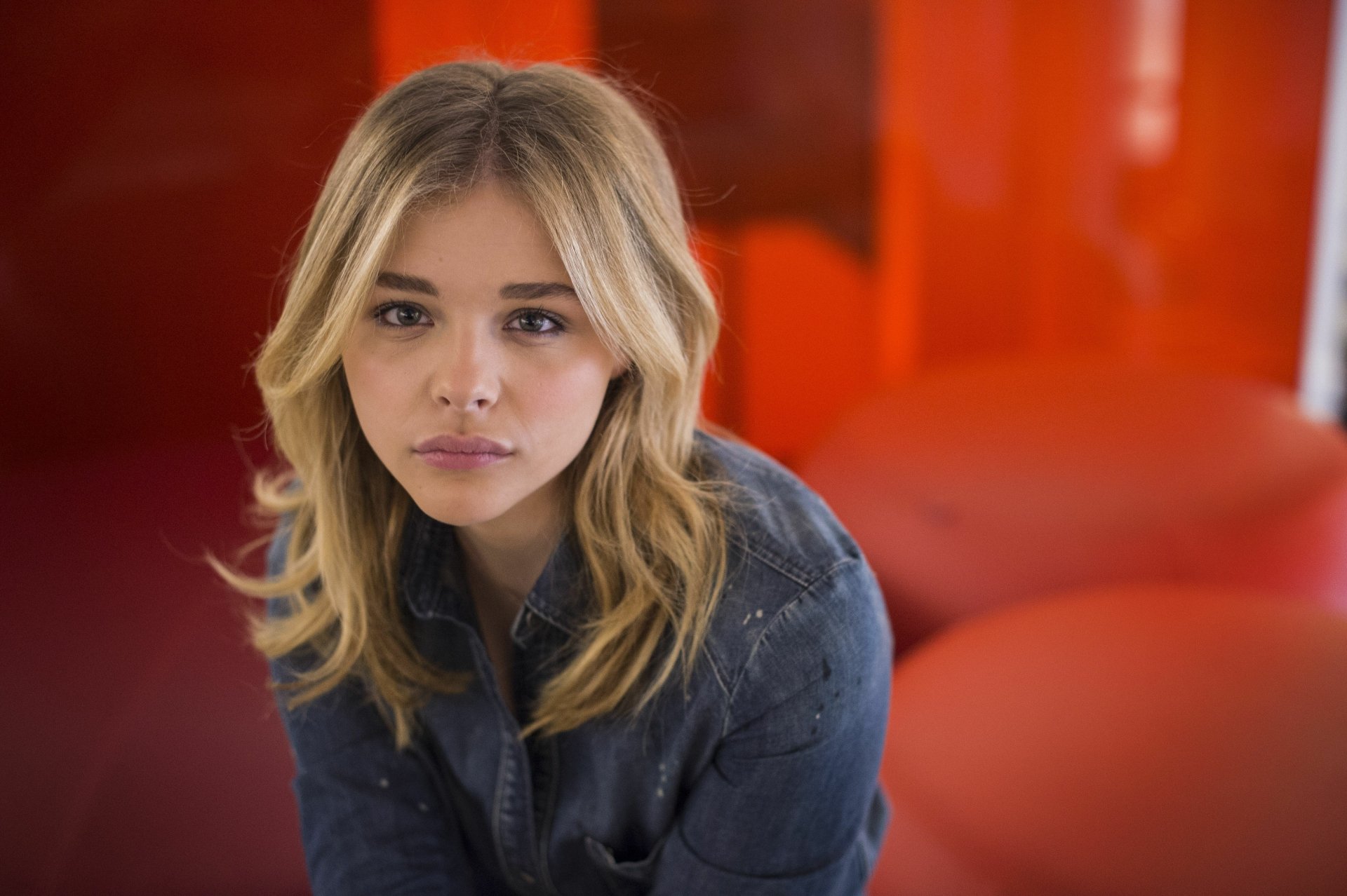 Close-up portrait of a blonde female celebrity seated against a red backdrop — 4K Ultra HD PC desktop wallpaper and background.
