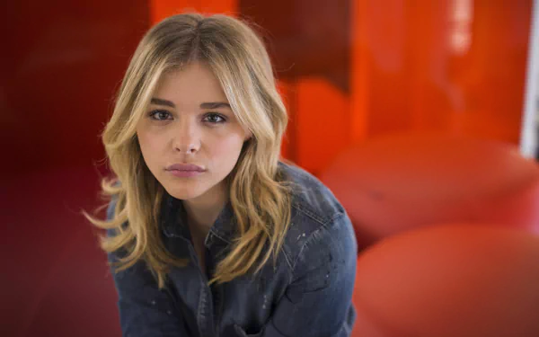Close-up portrait of a blonde female celebrity seated against a red backdrop — 4K Ultra HD PC desktop wallpaper and background.