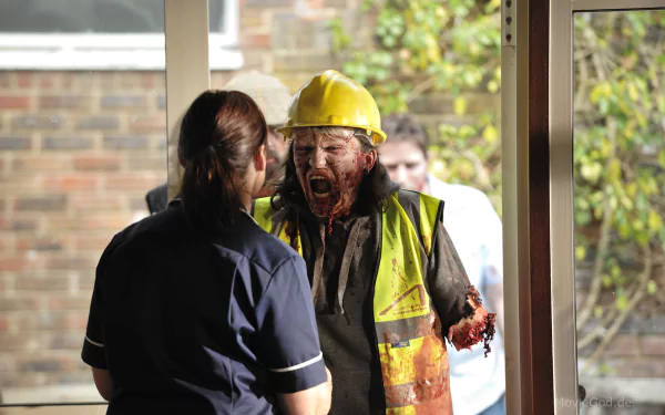 HD PC desktop wallpaper and background: still from the movie Cockneys vs Zombies — a bloodied construction-worker zombie in a hi‑vis vest and hard hat lunges at a nurse in a doorway.