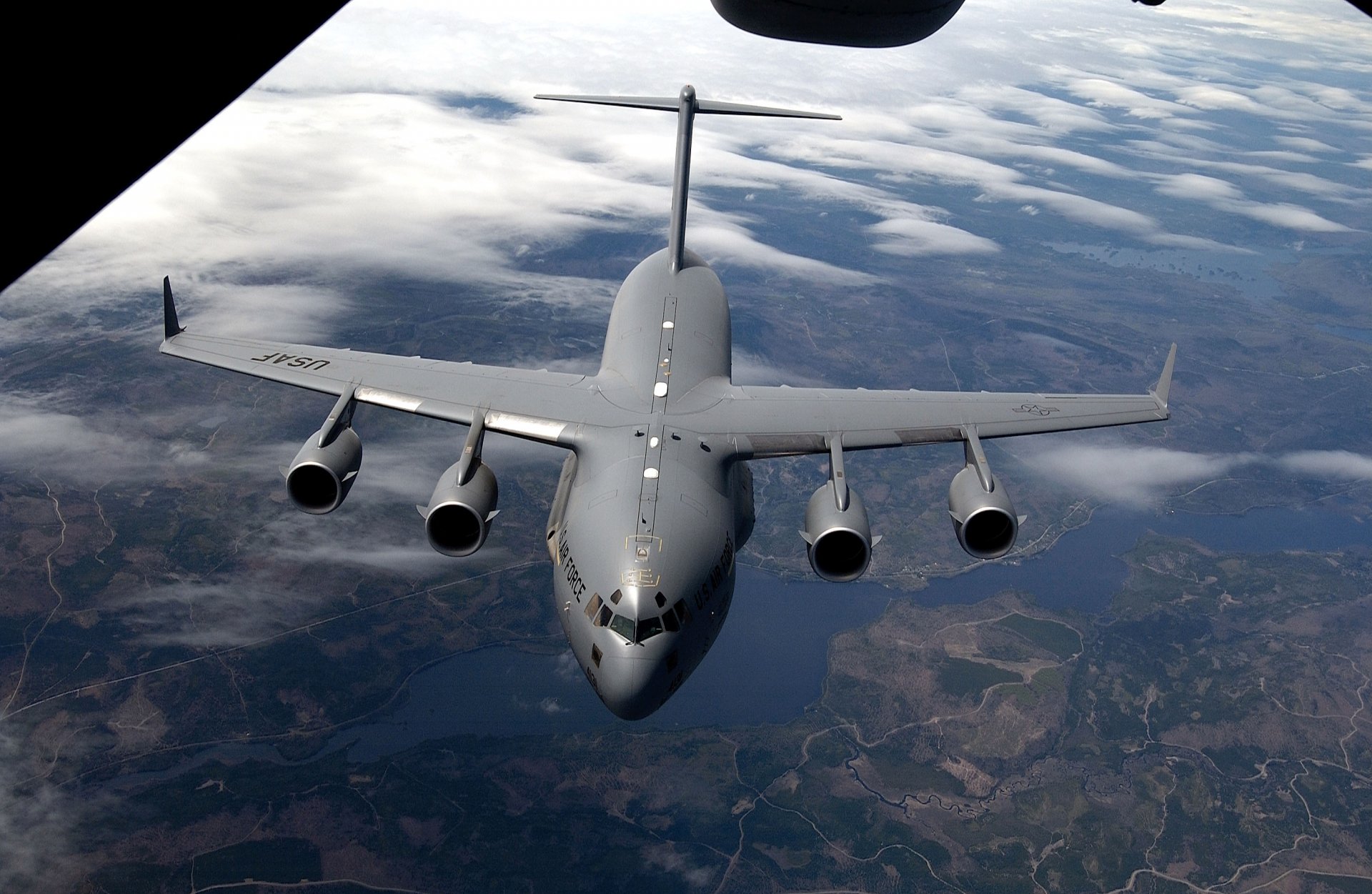 A Lockheed C-5 Galaxy military transport aircraft flying above the clouds, showcased as a high-definition PC desktop wallpaper and background.