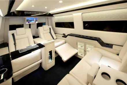 HD PC desktop wallpaper of a Mercedes‑Benz Sprinter interior: cream leather reclining seats, ambient lighting, built-in screen and cabinetry inside a luxury van vehicle.