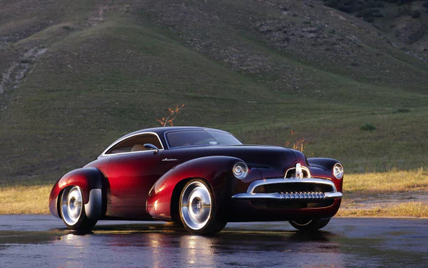 HD PC desktop wallpaper of glossy maroon Holden Efijy concept car on wet pavement with rolling green hills behind.