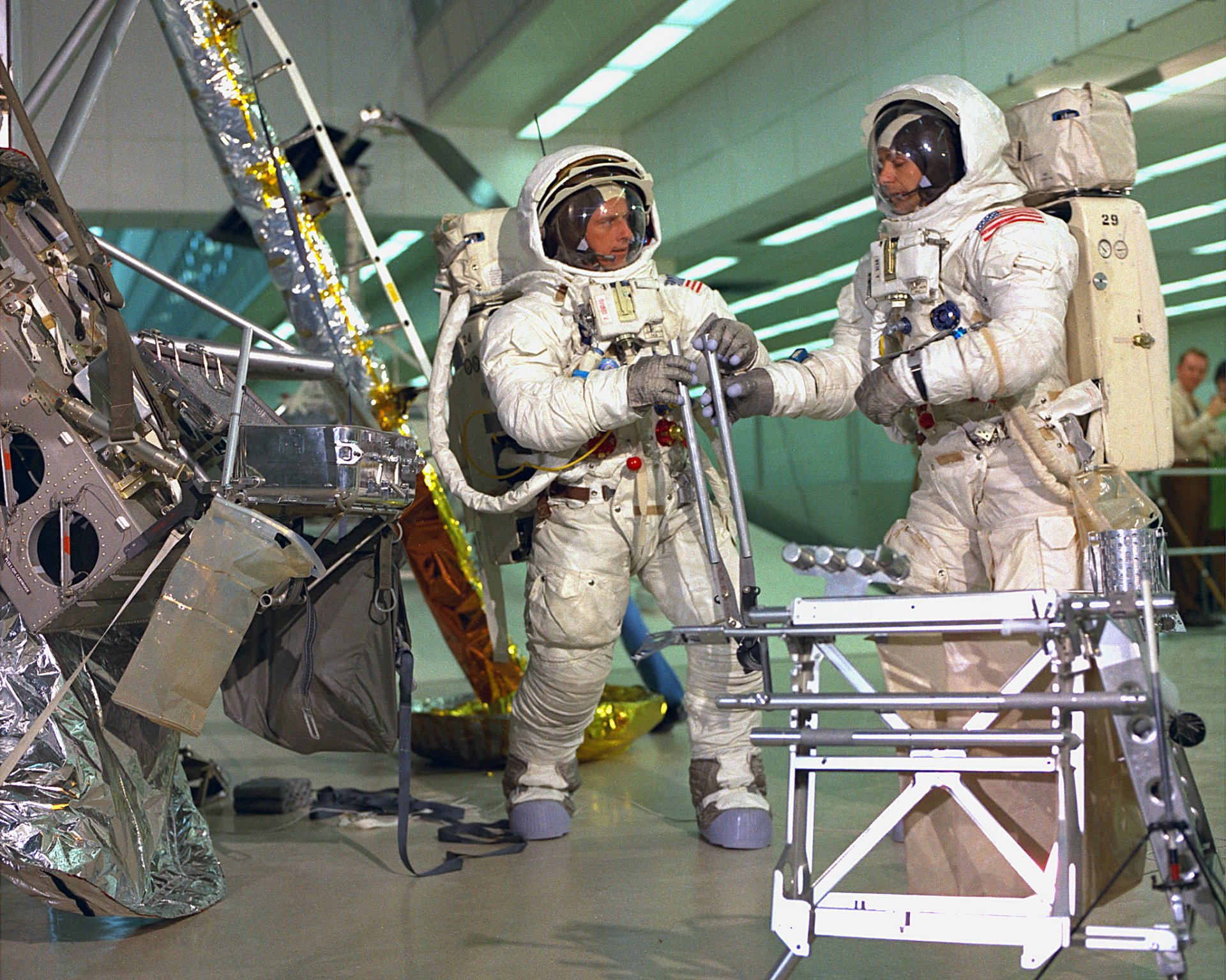 Astronauts in Apollo 12 space suits prepare for a mission at Kennedy Space Center, showcasing NASA's man-made space exploration technology.