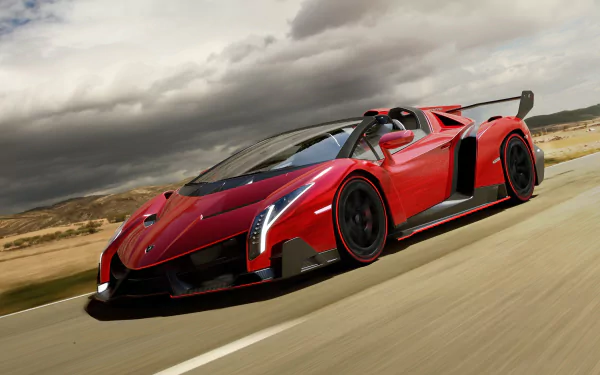 HD desktop wallpaper featuring a sleek red Lamborghini Veneno Roadster racing along an open road under a dramatic, cloudy sky.