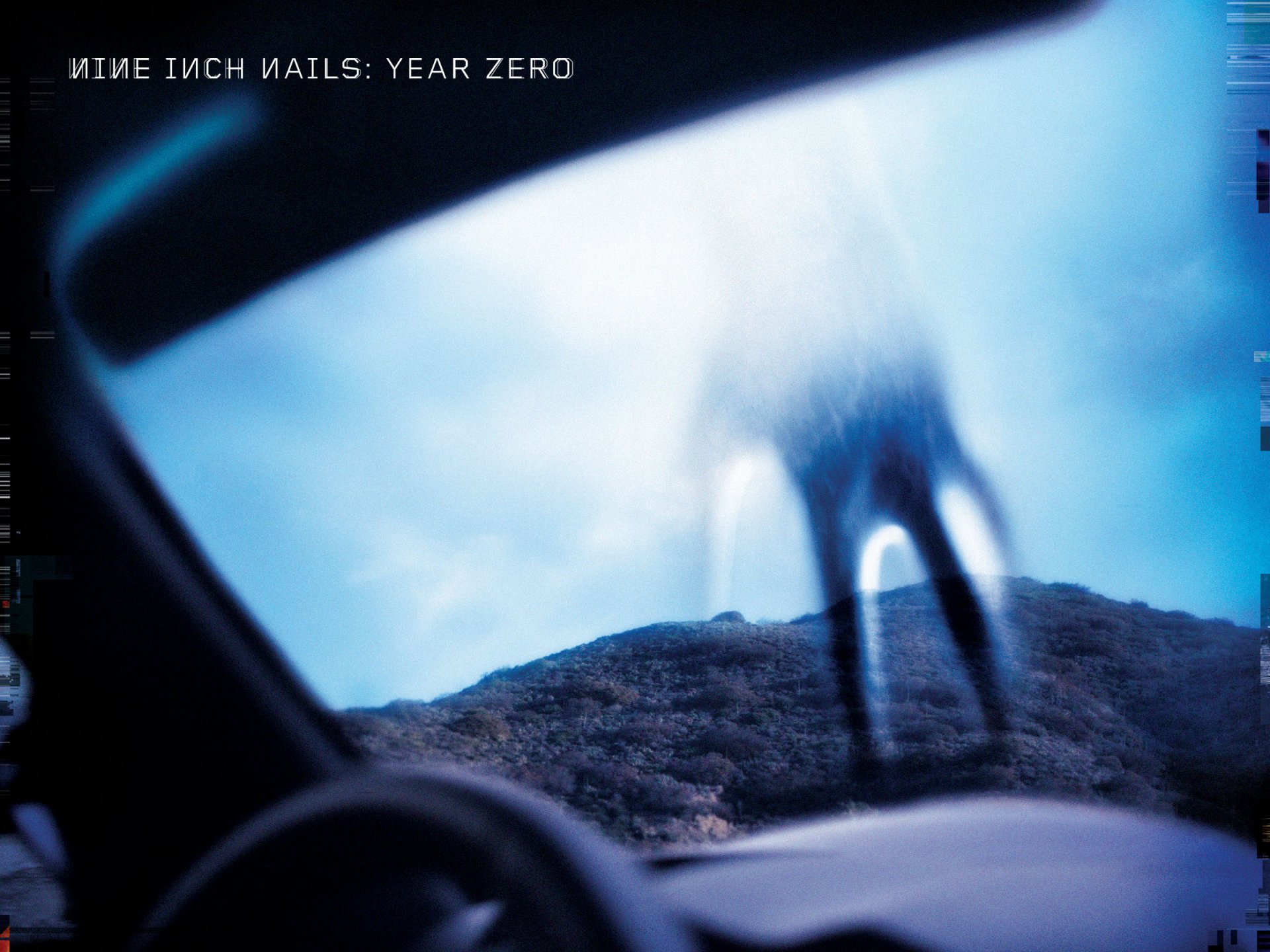 HD PC desktop wallpaper featuring a blurred, eerie figure outside a car window, evoking the dark, industrial atmosphere associated with Nine Inch Nails music.