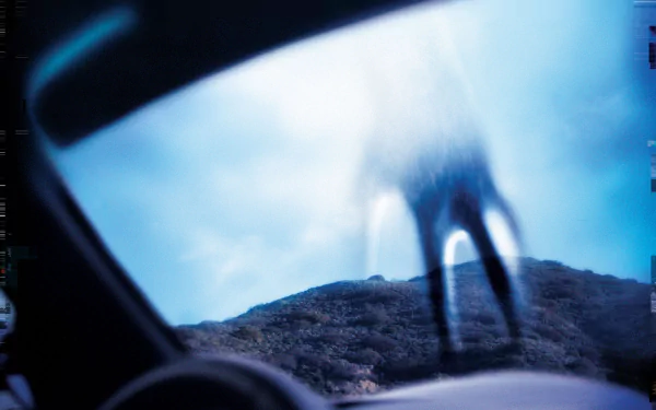 HD PC desktop wallpaper featuring a blurred, eerie figure outside a car window, evoking the dark, industrial atmosphere associated with Nine Inch Nails music.