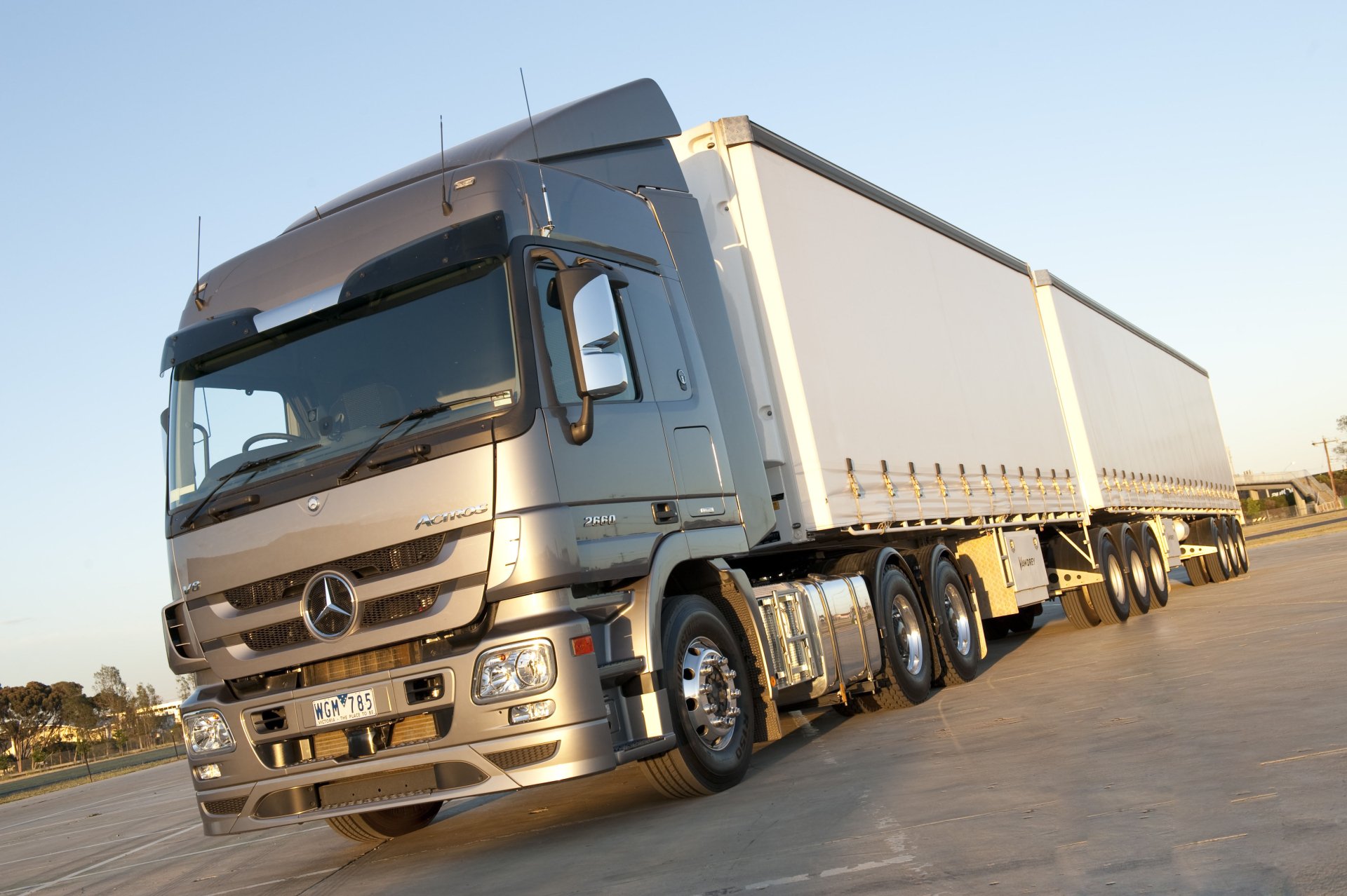 4K Ultra HD PC desktop wallpaper showing a silver Mercedes‑Benz vehicle: an articulated semi-truck with long curtain‑sided trailer on sunlit pavement.