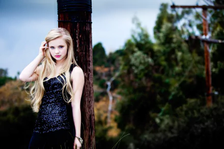 HD PC desktop wallpaper featuring woman Sierra McCormick with long blonde hair, wearing a black sequined dress, standing outdoors against a wooden post with greenery in the background.