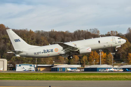 Boeing P-81 Neptune military aircraft of India takes off, captured in stunning 4K Ultra HD detail against a backdrop of autumn trees and runway buildings.