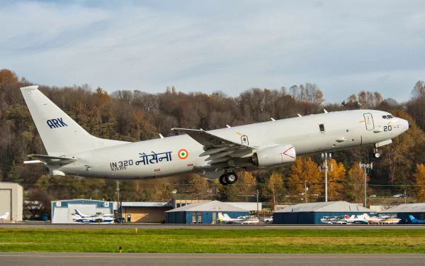 Boeing P-81 Neptune military aircraft of India takes off, captured in stunning 4K Ultra HD detail against a backdrop of autumn trees and runway buildings.