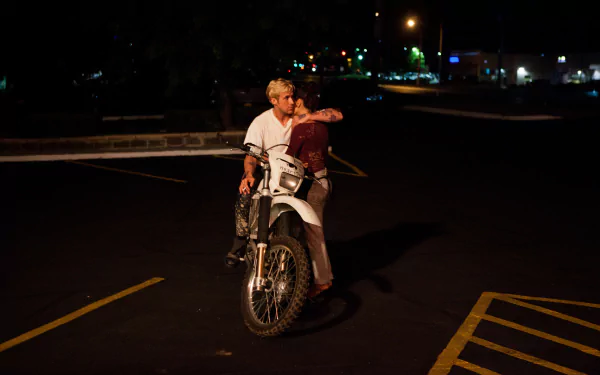 HD PC desktop wallpaper featuring Ryan Gosling and Eva Mendes as Luke and Romina from The Place Beyond the Pines movie, riding a motorcycle at night.