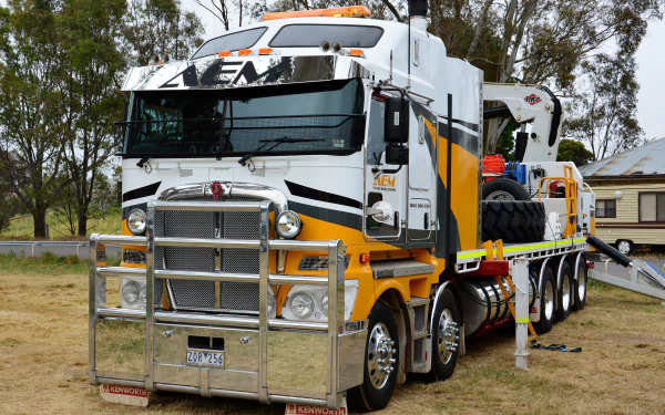 4K Ultra HD PC desktop wallpaper featuring a Kenworth vehicle, showcasing its detailed front and side in an outdoor setting with trees and a building in the background.
