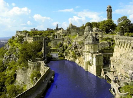 HD desktop wallpaper of a historic ruin in a mountainous region of India, featuring man-made water bodies, ancient structures, and a picturesque skyline with the city in the backdrop.