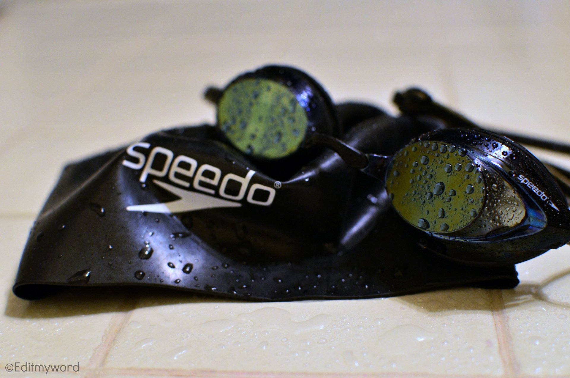 Close-up HD PC wallpaper of wet black Speedo swimming goggles and cap, highlighting sports gear for swimming.