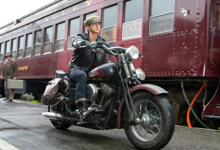 Shia LaBeouf riding a motorcycle beside a vintage train, from the movie Indiana Jones and the Kingdom of the Crystal Skull, captured as an HD PC desktop wallpaper.