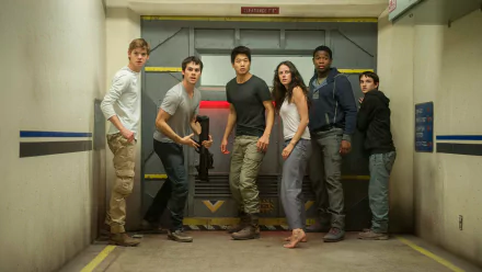 A scene from Maze Runner: The Scorch Trials featuring characters portrayed by Dylan O'Brien, Ki Hong Lee, Kaya Scodelario, Thomas Brodie-Sangster, and others, set in a suspenseful environment.