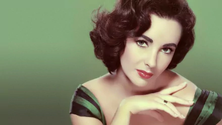A striking HD desktop wallpaper featuring actress Elizabeth Taylor, showcasing her elegant pose and captivating expression against a soft green background.