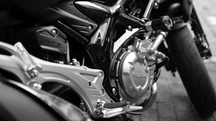 Close-up 4K Ultra HD wallpaper of a Suzuki motorcycle engine and rear wheel in black-and-white, showing detailed bike components and frame.