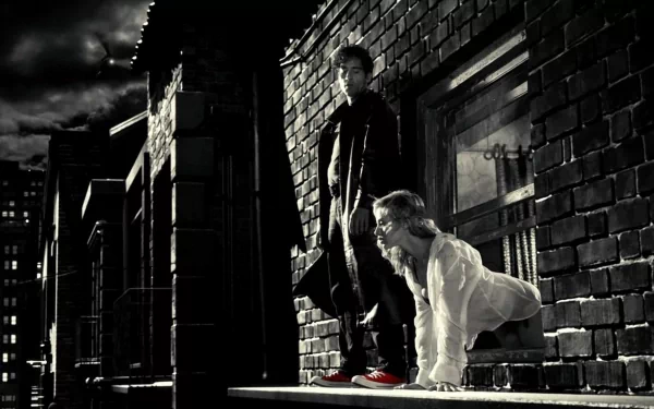 HD PC desktop wallpaper featuring a dark, gritty scene from the movie Sin City, showcasing two characters in black and white with striking red shoes.