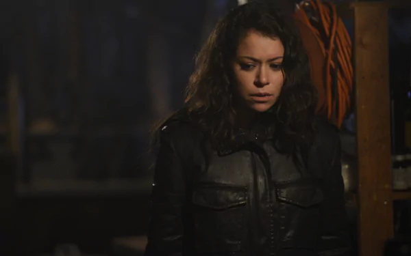 4K Ultra HD PC desktop wallpaper from the TV show Orphan Black: a tense, brooding woman in a dark jacket stands in a dimly lit storage space.