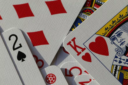 A close-up of playing cards featuring a King of Hearts and a 2 of Spades, set against a colorful backdrop, showcased as a 4K Ultra HD PC desktop wallpaper.