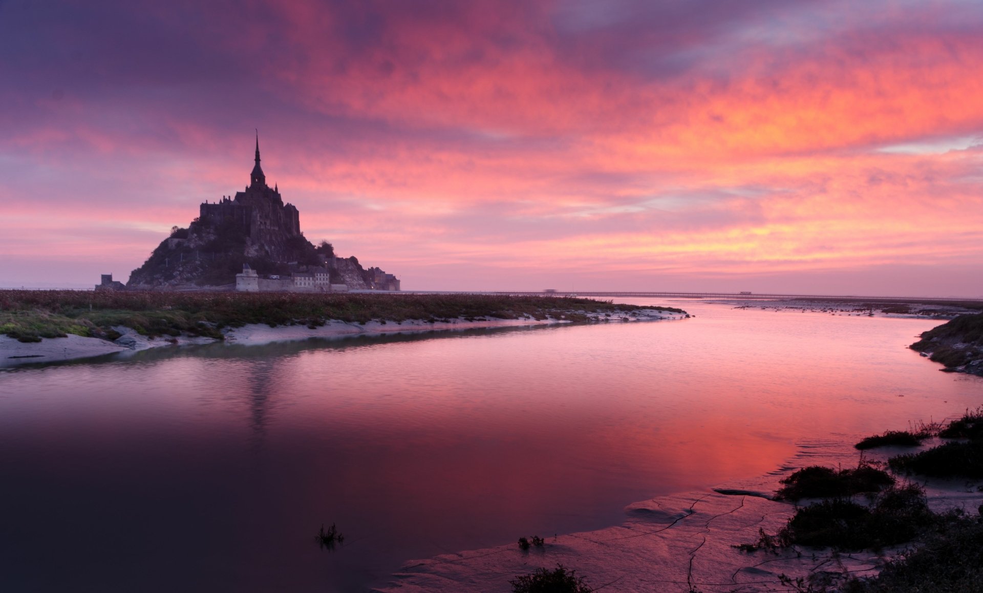 4K Ultra HD PC desktop wallpaper/background: Mont Saint-Michel religious abbey silhouetted at sunset, pink-purple sky and clouds mirrored in calm tidal waters.