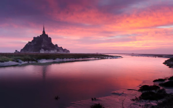 4K Ultra HD PC desktop wallpaper/background: Mont Saint-Michel religious abbey silhouetted at sunset, pink-purple sky and clouds mirrored in calm tidal waters.