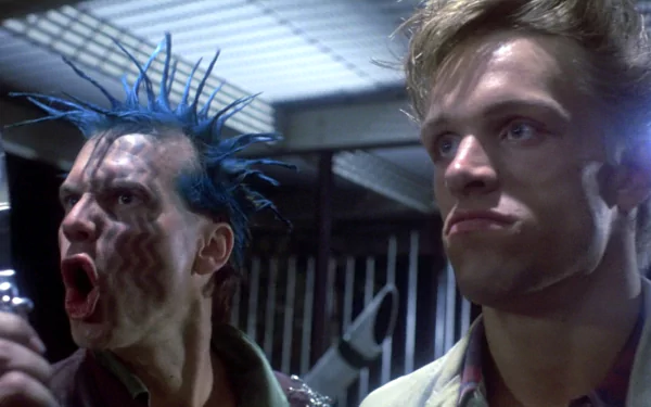 A scene from the movie The Terminator featuring two intense characters, one with blue spiked hair and the other looking stern, captured in high-definition for a dramatic desktop wallpaper.